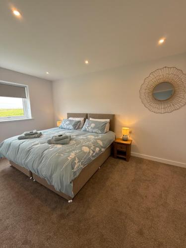 a bedroom with a bed and a mirror on the wall at Stylish Cosy Stunning View Villa in Kirkwall, Free Parking and WiFi in Orkney