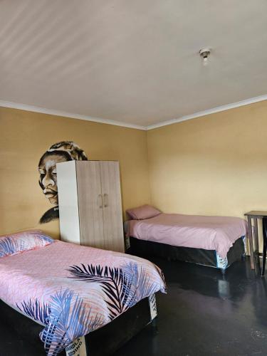 a room with two beds and a head on the wall at Nelspruit Madiva Guest House in Nelspruit