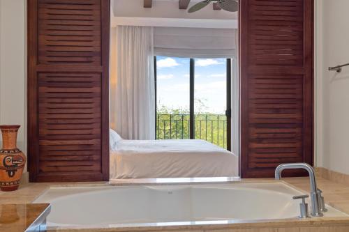 a bathroom with a large bath tub with a window at Treetop Ocean View Penthouse - Jobo 15 in Playa Conchal