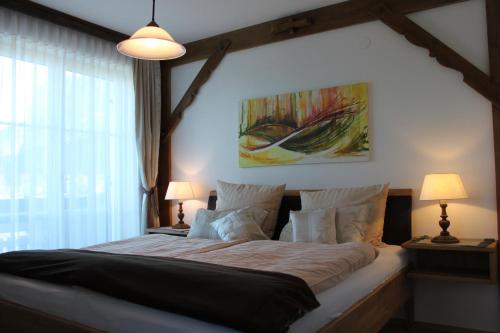 モントゼーにあるFerienwohnung Winklhoferのベッドルーム1室(大型ベッド1台、ランプ2つ付)