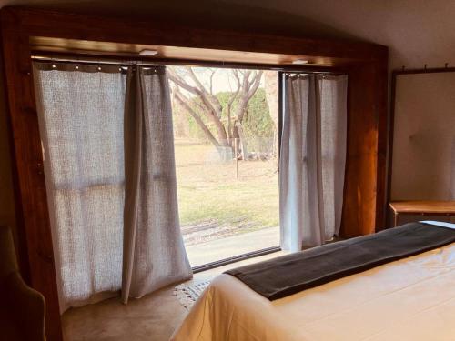 ein Schlafzimmer mit einem Bett und einem großen Fenster in der Unterkunft Glamping en zona de Bodegas Luján de Cuyo Mendoza in La Porteña