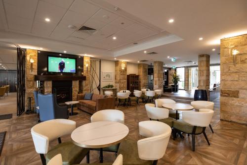 ein Restaurant mit Tischen und Stühlen und einem Fernseher in der Unterkunft Chateau Elan At The Vintage in Pokolbin