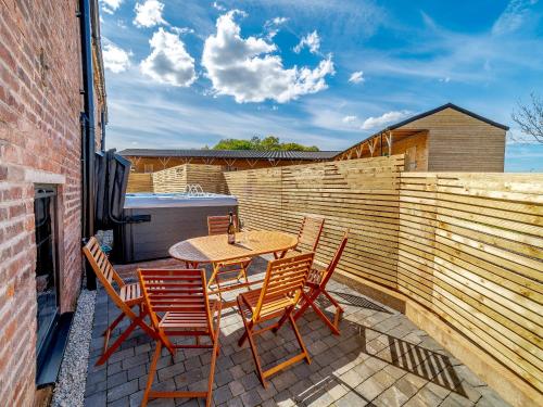 a patio with a table and chairs and a fence at Stable View Barn - Uk45938 in Corley