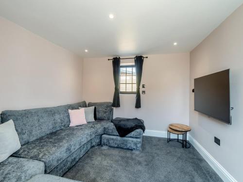 a living room with a couch and a flat screen tv at Stable View Barn - Uk45938 in Corley