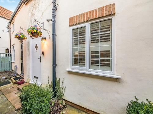 a white house with a window and a door at Rose Cottage - Uk45971 in Yarm