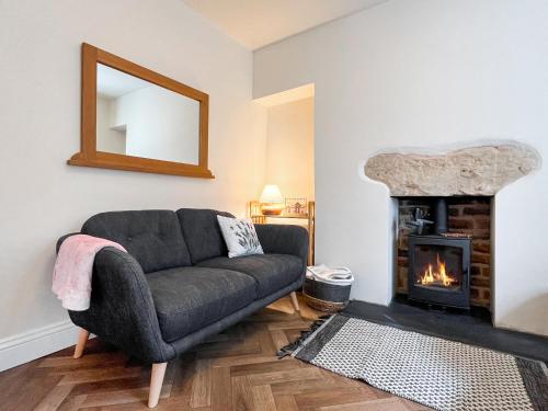 un soggiorno con divano e camino di Marsay Cottage a Loftus