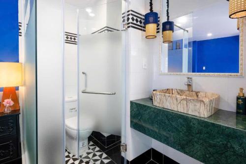a bathroom with a sink and a toilet and a mirror at Heritage hotel in Nha Trang