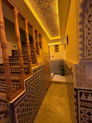 een gang met een trap met siertegels op de muren bij Riad Dar El bellar in Fès