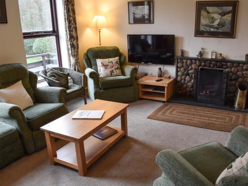 a living room with couches and a fire place at Ghyllside 3 in Ambleside