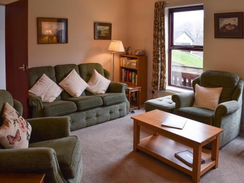 a living room with a couch and chairs and a table at Ghyllside 3 in Ambleside