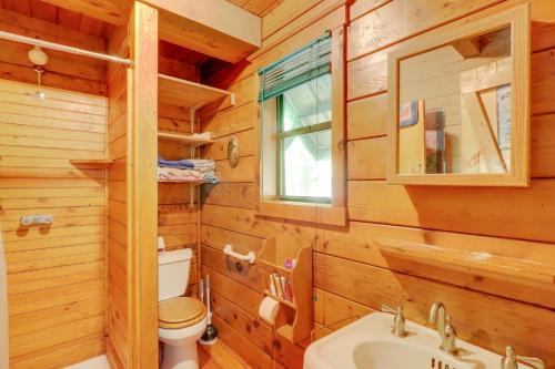 a log cabin bathroom with a toilet and a sink at Secluded Mountain Cabin with Decks and Gazebo! in Brasstown