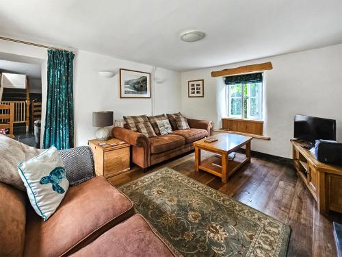 ein Wohnzimmer mit Sofa und Fernseher in der Unterkunft Ivy Cottage - Tq4 in Boscastle