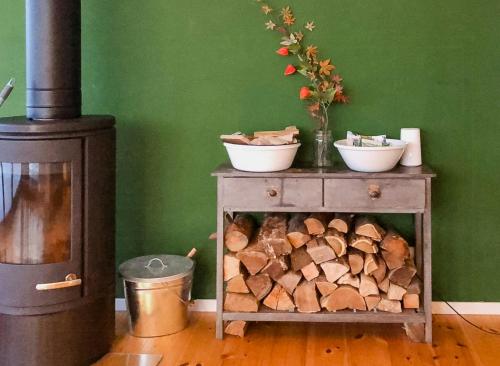 a table with two bowls on it next to a wood stove at Natural Wooden House With Panoramic View in Ihlow