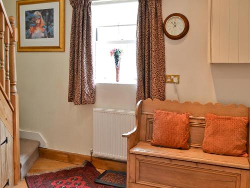 StaindropにあるFawn Lea Apartmentのベンチと時計付きの窓が備わる客室です。