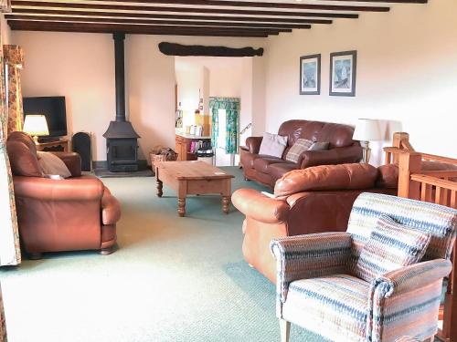 a living room with leather furniture and a fireplace at Chapman House in Parkham