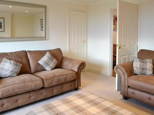 a living room with a couch and a chair at Foulden Hill Farm Cottage in Foulden