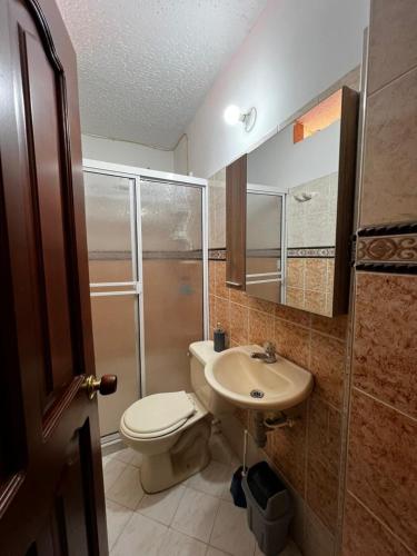 a bathroom with a toilet and a sink at Casa Rincón in Curití