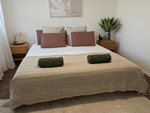 a bedroom with a large bed with two pillows on it at 10 min walk to beach & cafés with a quiet, private fenced garden in Byron Bay
