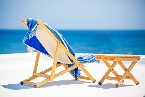 a beach chair with a blue and white towel at Sunhaus in Perissa