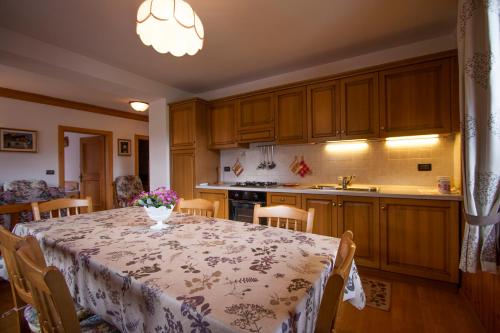 una cucina con un tavolo con un vaso di fiori sopra di Appartamenti Sergio Benedetti a Sappada
