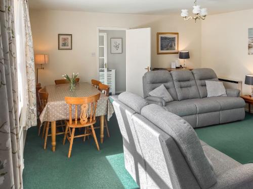 ein Wohnzimmer mit Tisch und Couch in der Unterkunft Shepherd's Cottage - Uk48872 in Belford