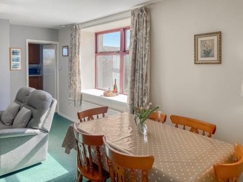 ein Esszimmer mit Tisch und Couch in der Unterkunft Shepherd's Cottage - Uk48872 in Belford