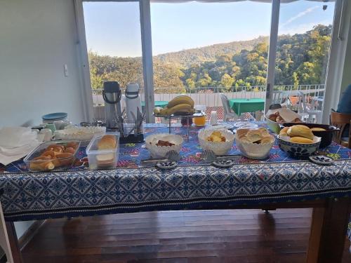 a table with many bowls of food on it at Pousada Essenza lindoía in Águas de Lindóia