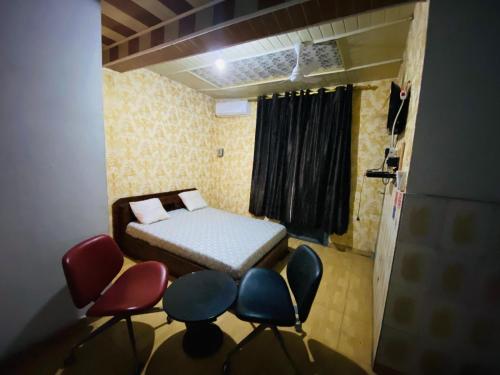 a small room with a bed and chairs in it at Flat Hôtel Alpha in Kinshasa