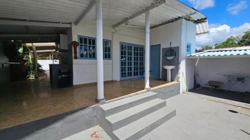 a large white house with a covered patio at Linda casa para temporada - Familia Munhoz Ventura in Cananéia