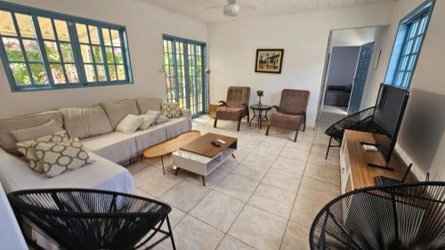 a living room with a couch and a tv at Linda casa para temporada - Familia Munhoz Ventura in Cananéia