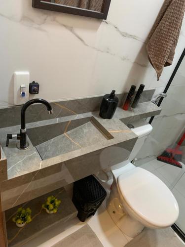 a bathroom with a sink and a toilet at Studio Centro Coité in Conceição do Coité