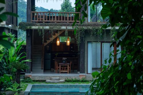 a house with a porch with a table and a deck at Elforest 3 in Payangan
