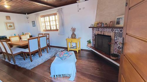un salon avec une table et une cheminée dans l'établissement Casa Serra Azul, à Campos do Jordão