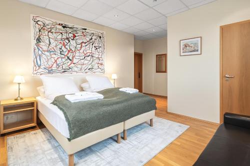 a bedroom with a bed with a painting on the wall at T10 Self check-in Hotel in Hafnarfjördur