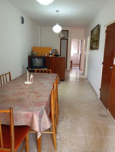 a dining room with a table and chairs and a living room at Departamento San Bernardo - 4 Ambientes - Cochera - Parrilla in San Bernardo