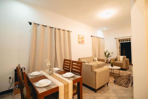 een woonkamer met een tafel en een eetkamer bij FREEDOM homes in Arusha