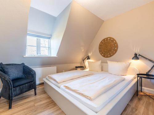 a bedroom with a large white bed and a chair at Wening-Hüs Wening-Hüs , in Boldixum