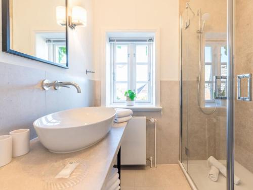 a bathroom with a white sink and a shower at Wening-Hüs Wening-Hüs , in Boldixum