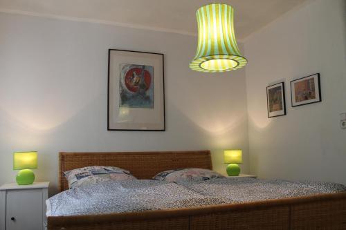 a bedroom with a bed with two lamps and a chandelier at Maison Mille Fleurs in Sankt Julian-Obereisenbach