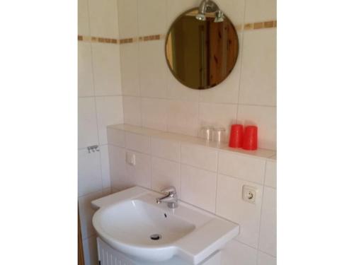 a white bathroom with a sink and a mirror at To the horse paddock in Zislow