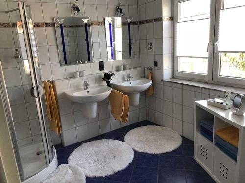 a bathroom with two sinks and a shower and mirrors at Spessart Romanticism in Blankenbach