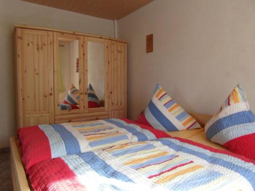 une chambre avec un lit et une armoire en bois dans l'établissement 1 in the holiday home Am Waldweg, à Arnoldshammer