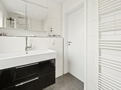a white bathroom with a sink and a mirror at Holiday home in Timmel with swimming pool in Timmel