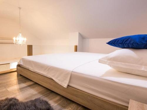 een slaapkamer met een groot wit bed met blauwe kussens bij Villa in Zavojane with swimming pool in Vodenjak