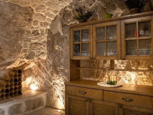 een keuken met een aanrecht en een stenen muur bij Villa in Zavojane with swimming pool in Vodenjak