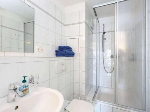 a white bathroom with a shower and a sink at Residence at the Spa Park 2 in Warnemünde