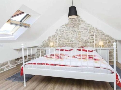 een wit bed in een kamer met een stenen muur bij Villa in Zagvozd with swimming pool in Šarići