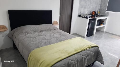 a bedroom with a bed with a yellow blanket on it at Rada Tilly Apart 2 Unidad 6 in Rada Tilly