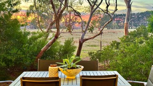 a table with a plant and two vases on it at The Nature Resort Villas in Cowes