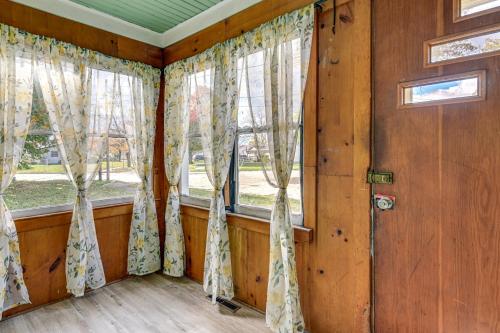 a room with wooden walls and windows with curtains at 3 Mi to Dtwn Saginaw Cozy Family Home with Yard! in Saginaw